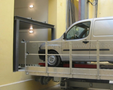 Piattaforma di sollevamento del sistema Translift con veicolo in fase di movimentazione a Firenze.