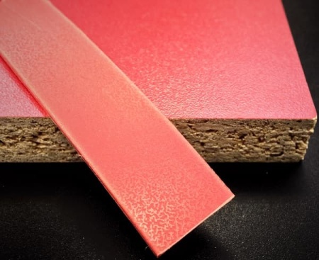 Кромочная лента ПВХ 0,4*19 мм BR740 с плитой ЛДСП 16 мм красная.