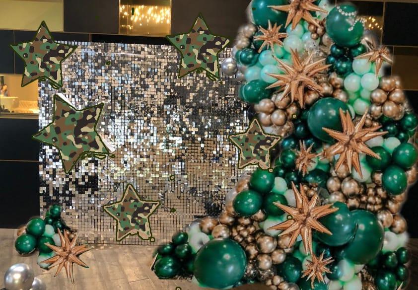 фотозона из серебряных пайеток с пышной гирляндой и звёздами-камуфляж на 23 февраля