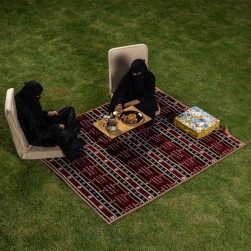 Alsanidi, a floor seating mat for trips, camping, and desert outings, padded with sponge, traditional rug, wooden *oudi.