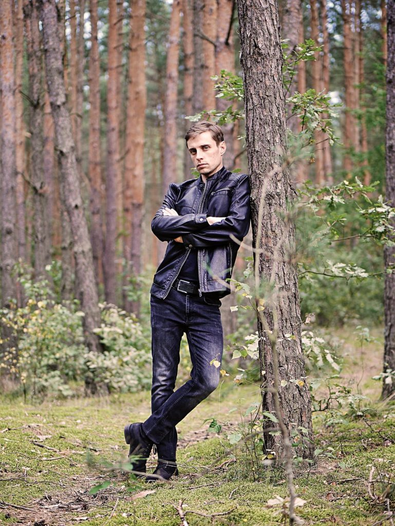 man wearing leather jacket in forest